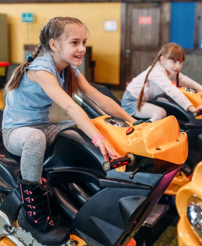 girls playing arcade game cropped